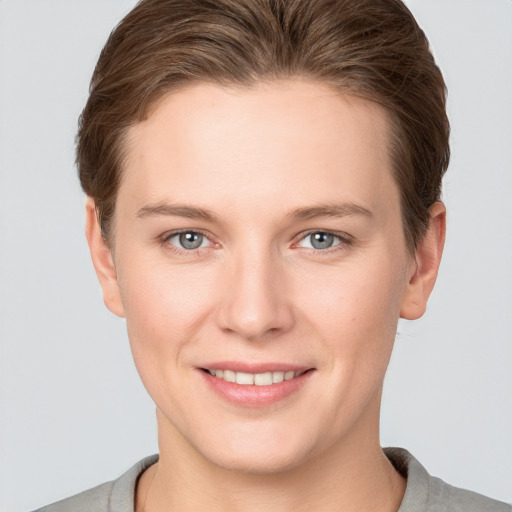 Joyful white young-adult female with short  brown hair and grey eyes