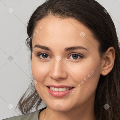 Joyful white young-adult female with long  brown hair and brown eyes