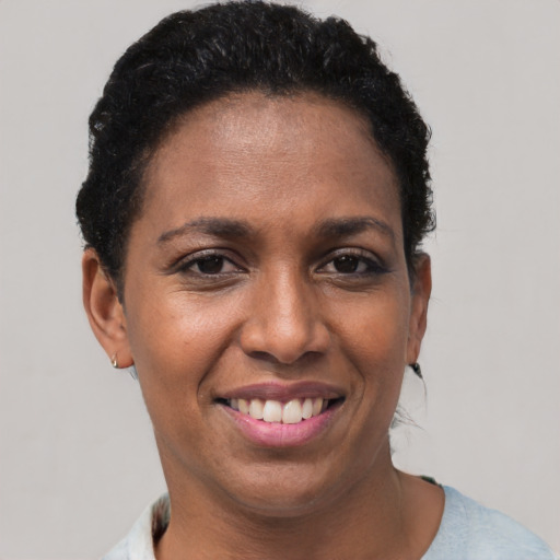 Joyful black young-adult female with short  brown hair and brown eyes