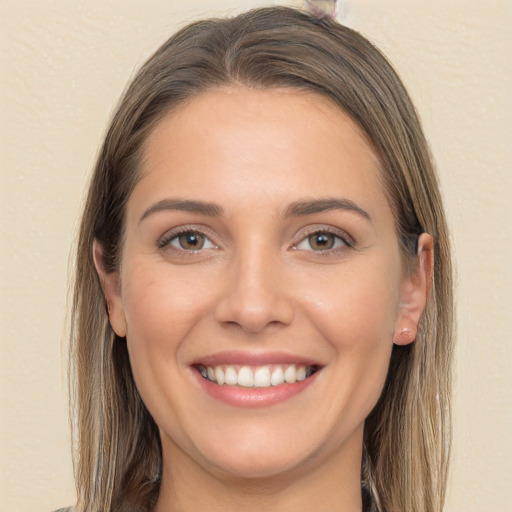 Joyful white young-adult female with long  brown hair and brown eyes