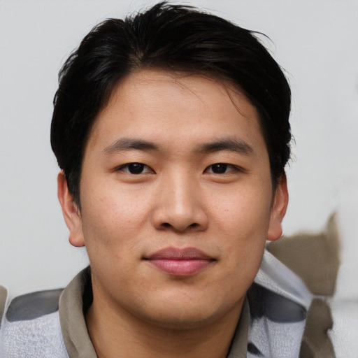 Joyful asian young-adult male with short  brown hair and brown eyes