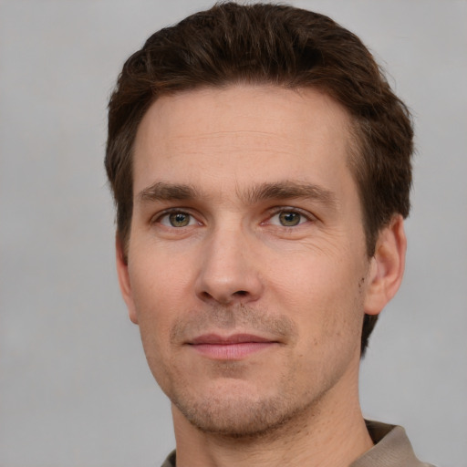 Joyful white adult male with short  brown hair and grey eyes