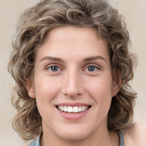 Joyful white young-adult female with medium  brown hair and blue eyes