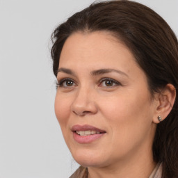 Joyful white adult female with long  brown hair and brown eyes