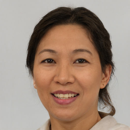 Joyful asian adult female with medium  brown hair and brown eyes