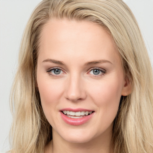 Joyful white young-adult female with long  brown hair and blue eyes