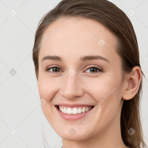 Joyful white young-adult female with long  brown hair and grey eyes