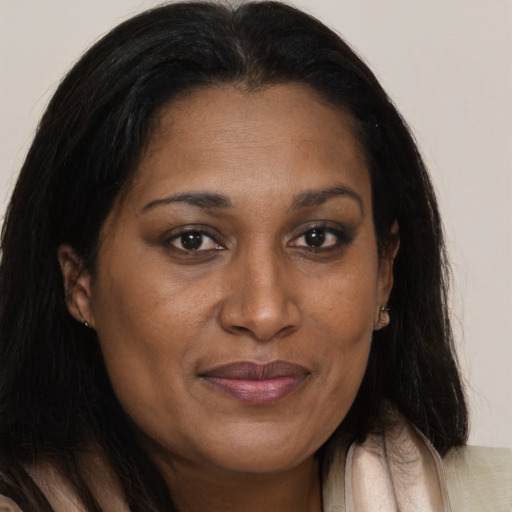 Joyful black adult female with long  brown hair and brown eyes