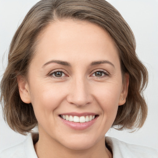 Joyful white young-adult female with medium  brown hair and grey eyes