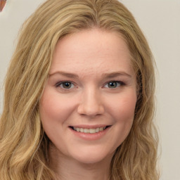 Joyful white young-adult female with long  brown hair and green eyes