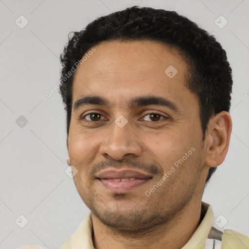 Joyful latino young-adult male with short  black hair and brown eyes