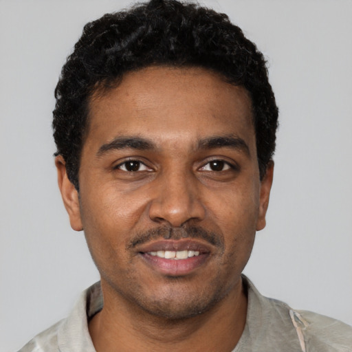 Joyful black young-adult male with short  black hair and brown eyes