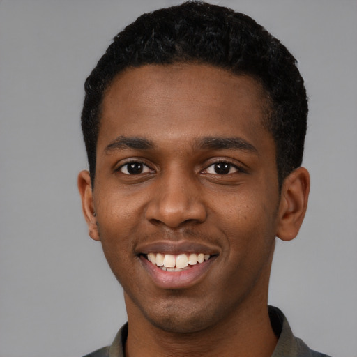 Joyful black young-adult male with short  black hair and brown eyes
