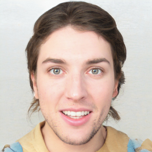 Joyful white young-adult male with short  brown hair and green eyes