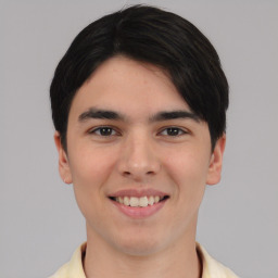 Joyful white young-adult male with short  black hair and brown eyes