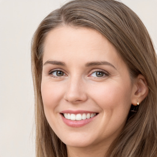 Joyful white young-adult female with long  brown hair and grey eyes