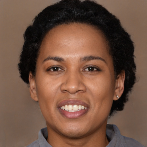 Joyful black adult female with short  black hair and brown eyes