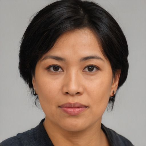 Joyful asian adult female with medium  black hair and brown eyes