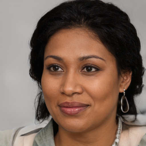 Joyful black adult female with medium  brown hair and brown eyes