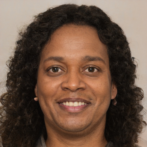 Joyful black adult female with long  brown hair and brown eyes