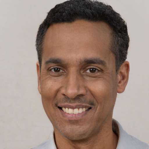 Joyful latino adult male with short  black hair and brown eyes