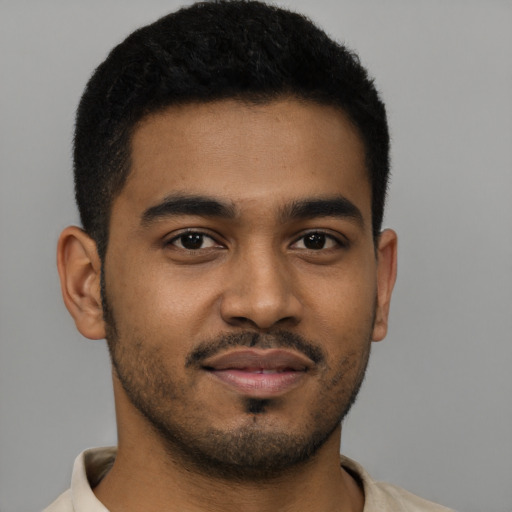 Joyful black young-adult male with short  brown hair and brown eyes