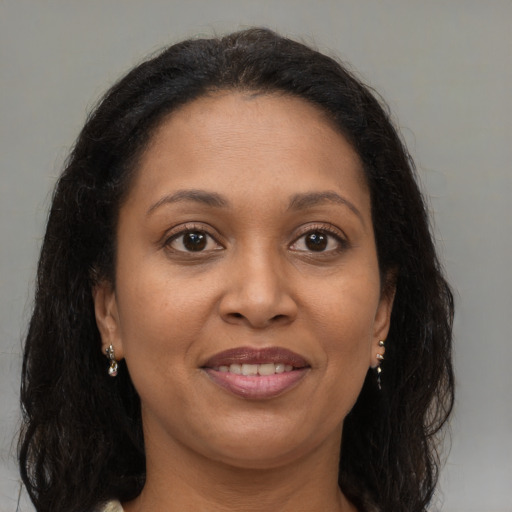 Joyful black adult female with long  brown hair and brown eyes