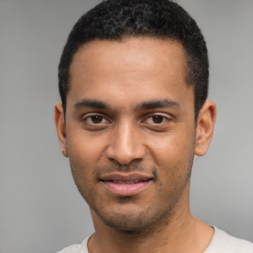 Joyful black young-adult male with short  black hair and brown eyes