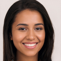 Joyful latino young-adult female with long  brown hair and brown eyes