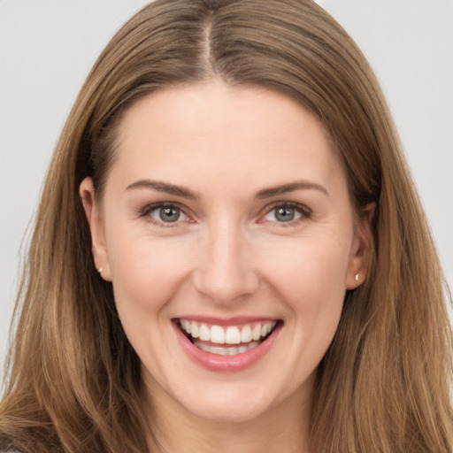 Joyful white young-adult female with long  brown hair and brown eyes