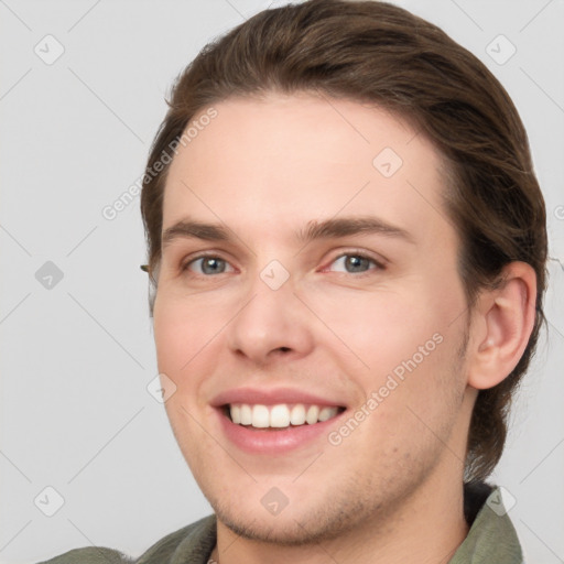 Joyful white young-adult male with medium  brown hair and grey eyes