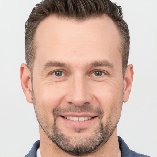 Joyful white adult male with short  brown hair and brown eyes