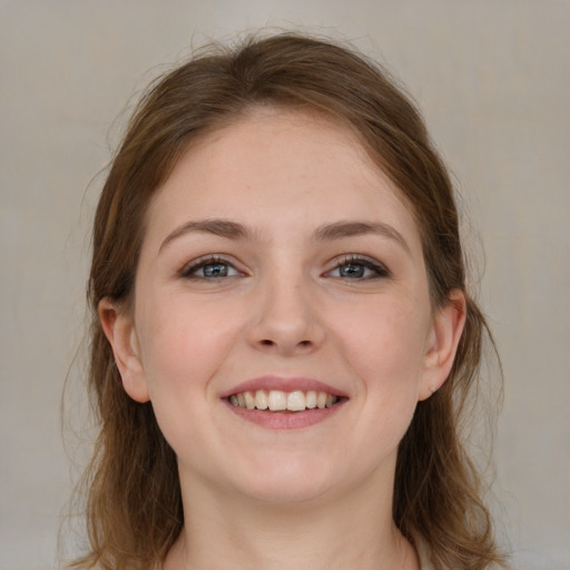 Joyful white young-adult female with medium  brown hair and grey eyes