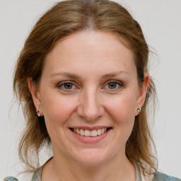 Joyful white young-adult female with medium  brown hair and blue eyes