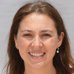 Joyful white adult female with long  brown hair and brown eyes