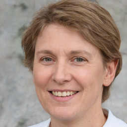 Joyful white adult female with medium  brown hair and grey eyes