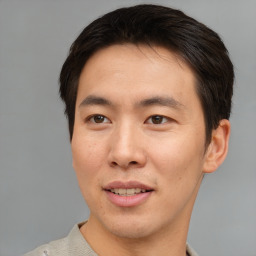 Joyful asian young-adult male with short  brown hair and brown eyes