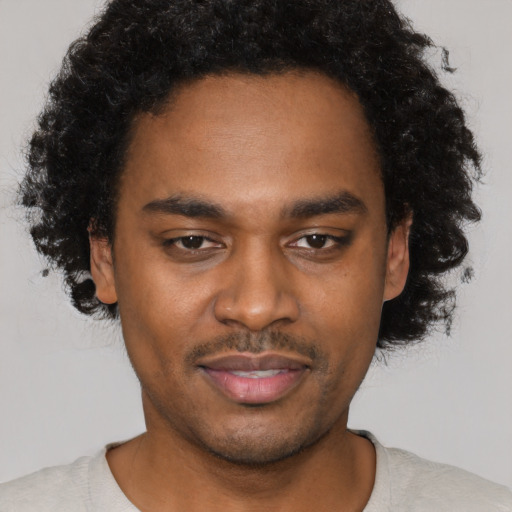 Joyful black young-adult male with short  black hair and brown eyes
