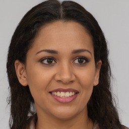 Joyful latino young-adult female with long  brown hair and brown eyes