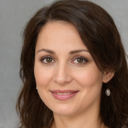 Joyful white adult female with long  brown hair and brown eyes