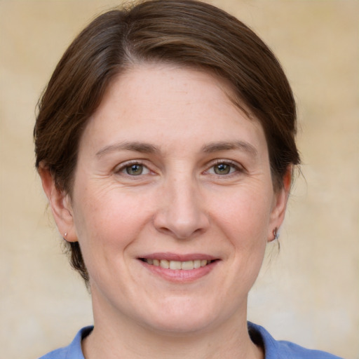 Joyful white adult female with medium  brown hair and grey eyes