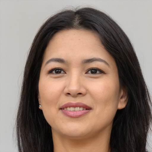 Joyful asian young-adult female with long  brown hair and brown eyes