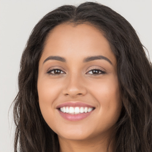 Joyful latino young-adult female with long  brown hair and brown eyes