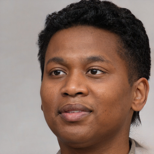 Joyful black young-adult male with short  black hair and brown eyes