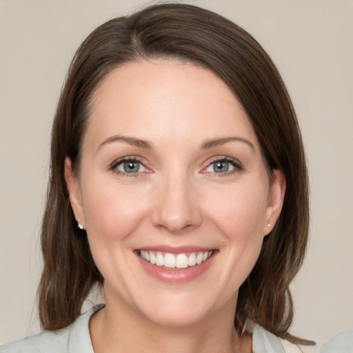 Joyful white young-adult female with medium  brown hair and green eyes