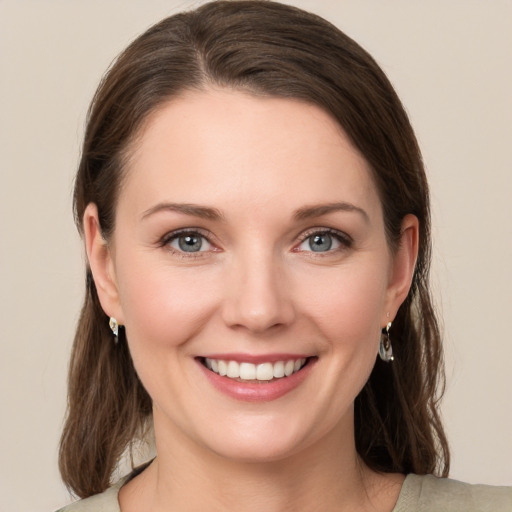 Joyful white young-adult female with medium  brown hair and green eyes