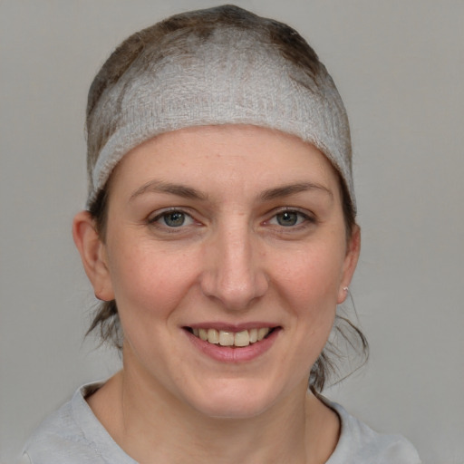 Joyful white young-adult female with medium  brown hair and blue eyes