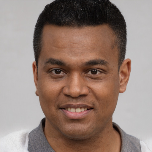 Joyful latino young-adult male with short  black hair and brown eyes