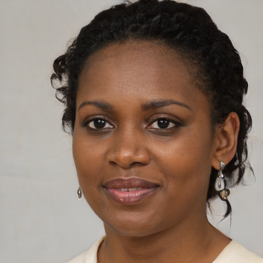 Joyful black young-adult female with medium  black hair and brown eyes