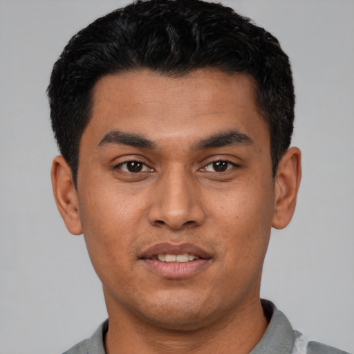 Joyful latino young-adult male with short  black hair and brown eyes